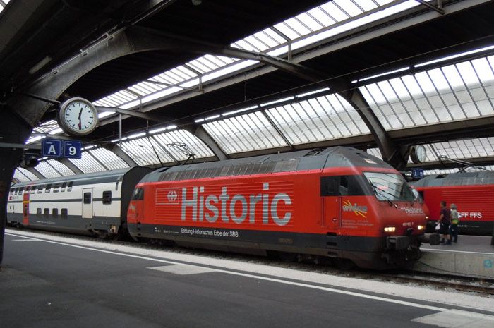La Fundación que gestiona los trenes históricos de los Ferrocarriles federales suizos, pasea este enorme logo en los laterales de la 460-102 en la estación de Zürich con un tren regional de dos pisos.