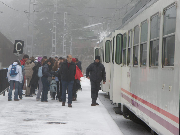 Viajeros descienden del tren en la helada estación del Puerto de Navacerrada