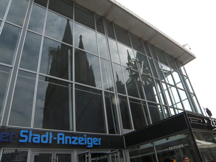 La imagen de las aguajas de la catedral se refleja en el vitral de la estación de Colonia