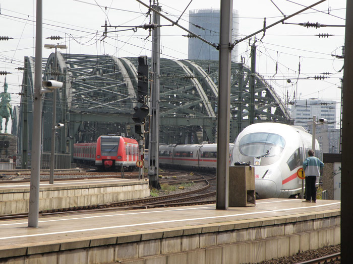 Un tren de cercanías y un ICE entran en paralelo desde el puente Hohenzollern a la estación