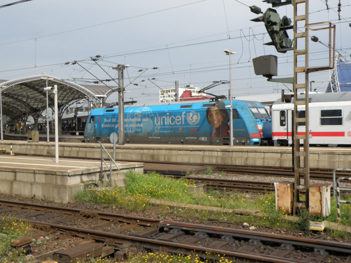 Una decorada locomotora de la DB entra con un tren de coches de viajeros a la estación