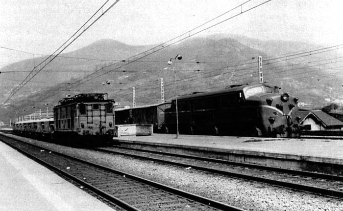 Dos épocas de la tracción eléctrica en Asturias: Una locomotora de la serie 6000 y a su lado, otra de la serie 7700.