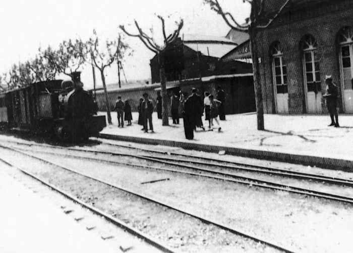 1942 estación de Valencia Jesús. Un largo tren de tracción vapor entraba con coches de dos ejes, junto a un andén arbolado. 