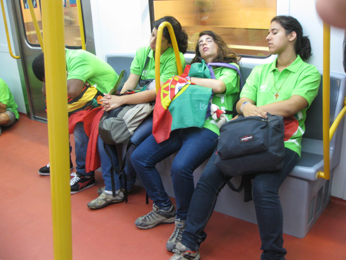 Un grupo de peregrinos voluntarios portugueses dormitando en el interior de un tren de Metro.