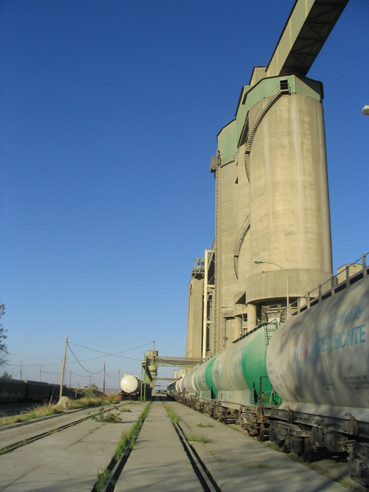 Grupo de vagones cisterna para cemento a granel bajo los silos de la cementera