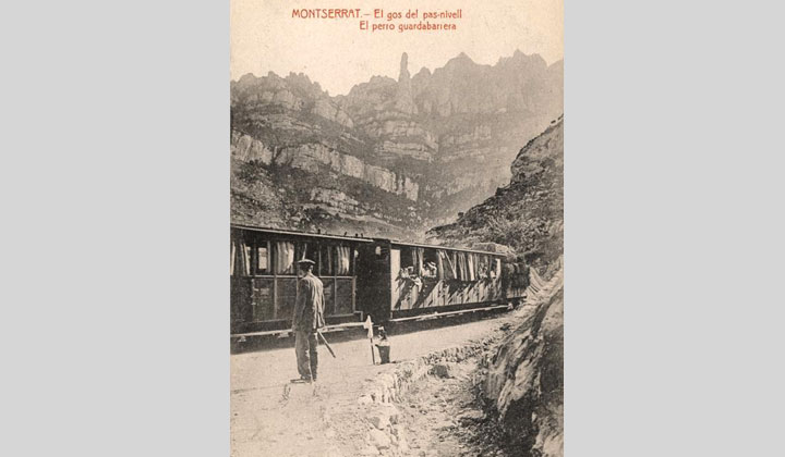 Guardabarrera y perro guardabarrera del ferrocarril de cremallera de Monistrol a Montserrat en el momento en que pasa un tren de viajeros. Archivo Histórico Ferroviario TP-IF-0962